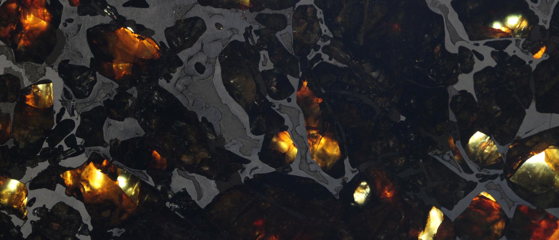 Pallasite meteorite composed of iron and brown-green olivine crystals